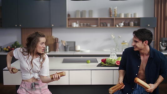 一对夫妇在厨房和面包蛋糕打架视频的预览图
