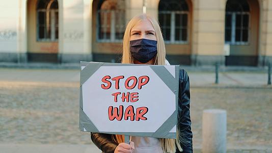 这位年轻女子呼吁通过拿着流水器停止战争视频的预览图