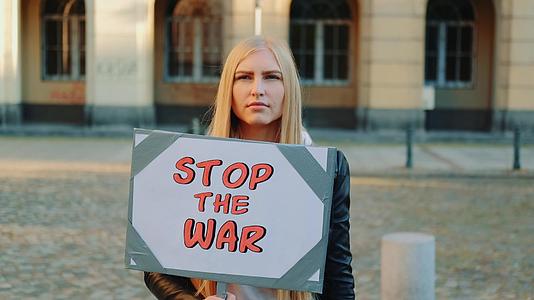 这位年轻女子呼吁通过拿着流水器停止战争视频的预览图