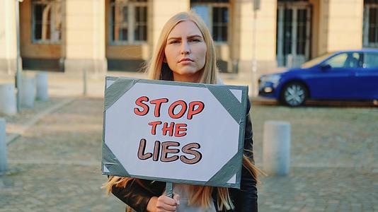 女性追随者用抗议横幅呼吁停止谎言视频的预览图