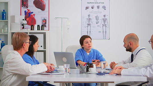 护士坐在会议桌前向团队解释研究信息视频的预览图