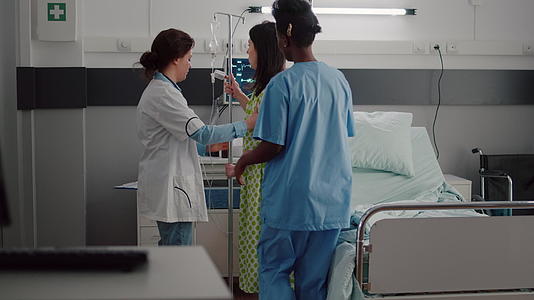 医疗团队帮助患者从床上站起来进行静脉注射iv流体滴液袋视频的预览图