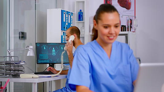 男护士在医院接待中接听电话视频的预览图