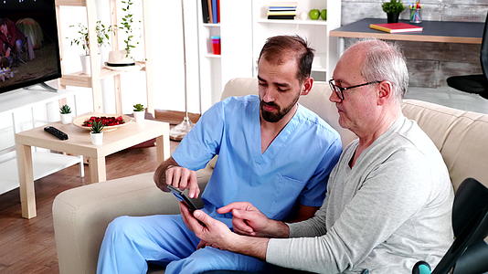 年轻男医生教老年人使用智能手机请使用智能手机视频的预览图