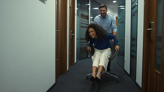 在走廊公司工作场所公司团队享受赛车办公椅的乐趣视频的预览图