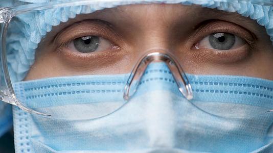 女医生脸上戴着安全眼镜的眼睛肖像医疗女性在医院或诊所视频的预览图
