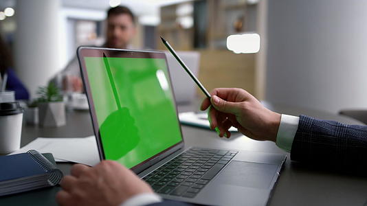 使用笔记本电脑绿屏的商务人士在会议桌上分析公司数据视频的预览图