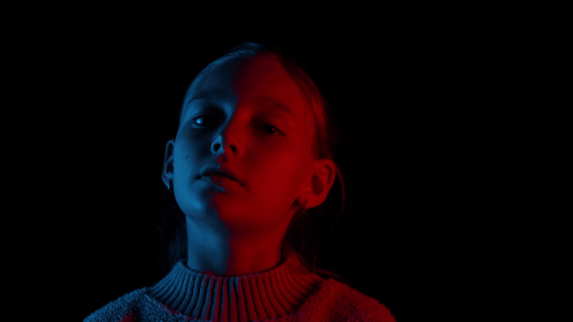深沉的女孩在黑暗中看着相机的肖像视频的预览图
