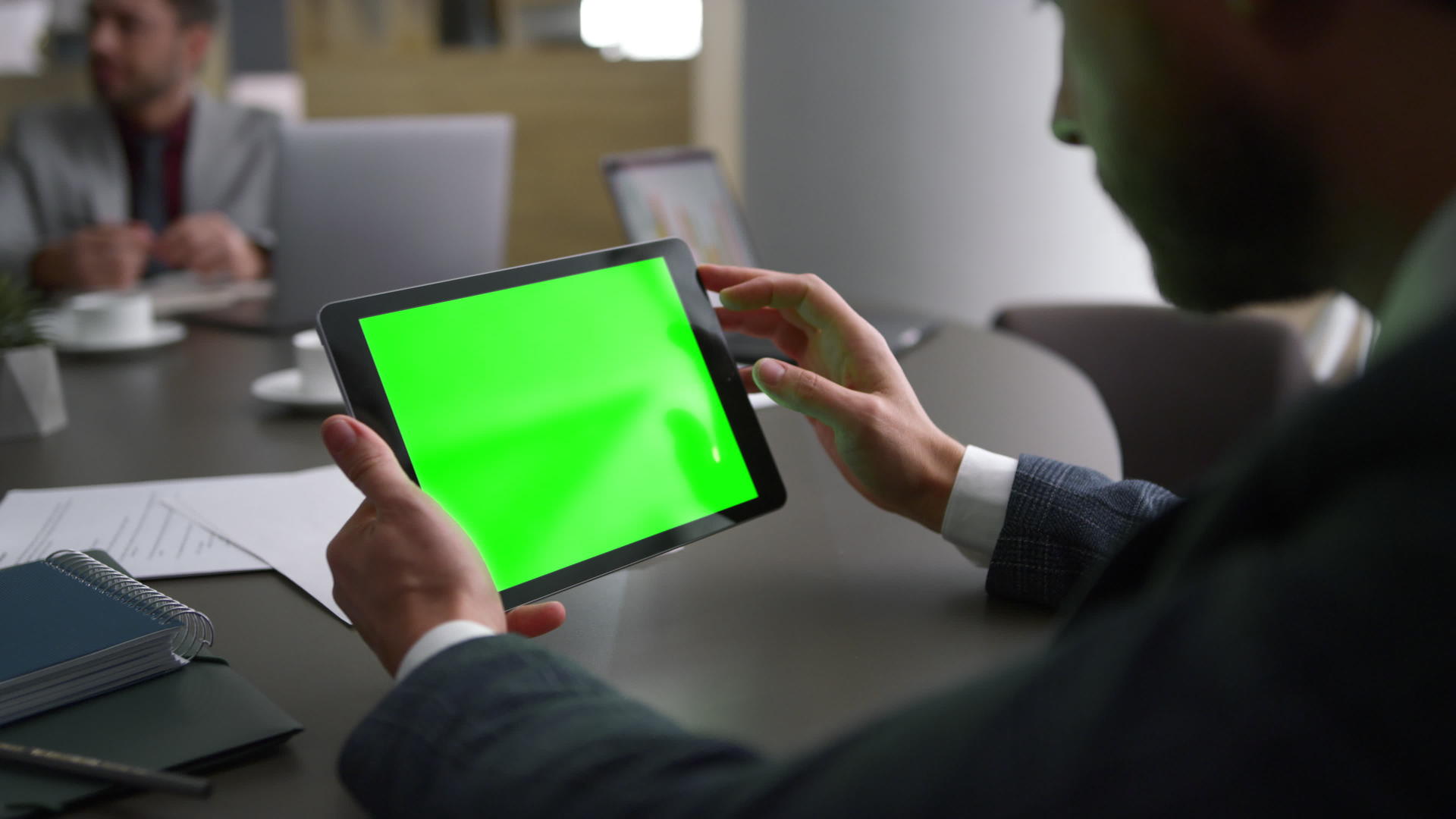 商务人士在工作场所使用平板设备绿屏查看公司新闻视频的预览图