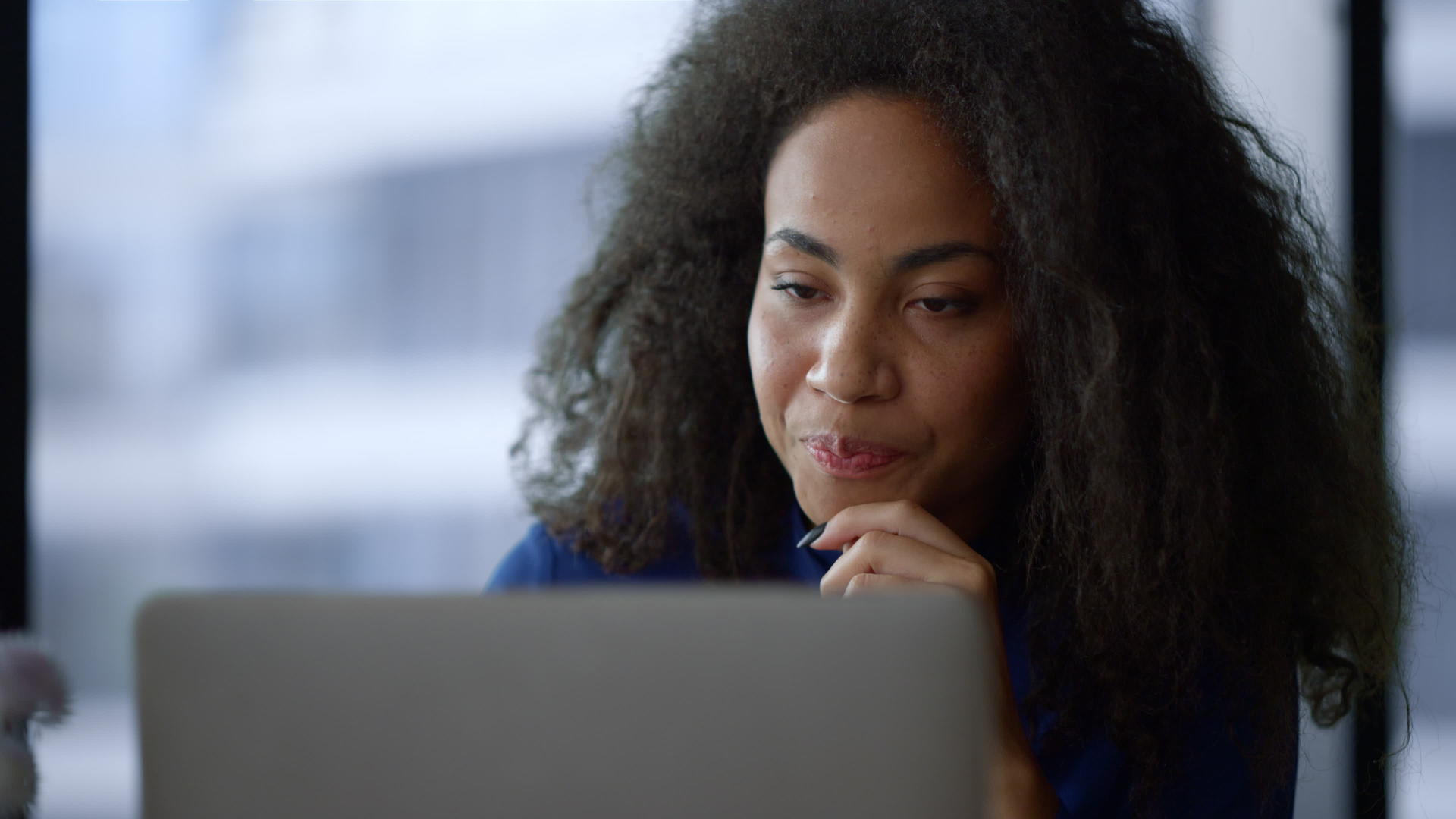 非洲裔美国女商人专注于在家庭办公室搜索笔记本电脑互联网视频的预览图