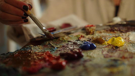创意女性在室内使用刷子不知名的画家在演播室搅拌油漆视频的预览图