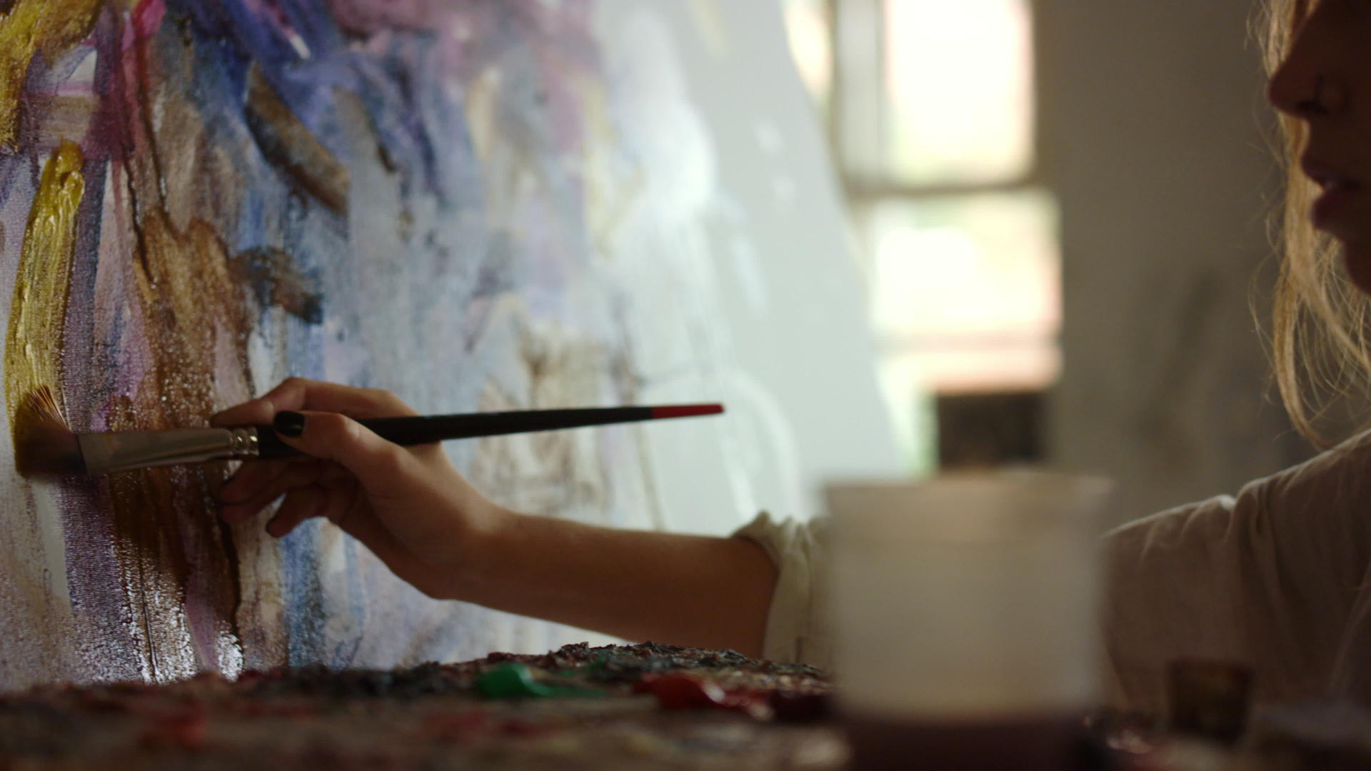 画室里的女画家用画笔画油画视频的预览图