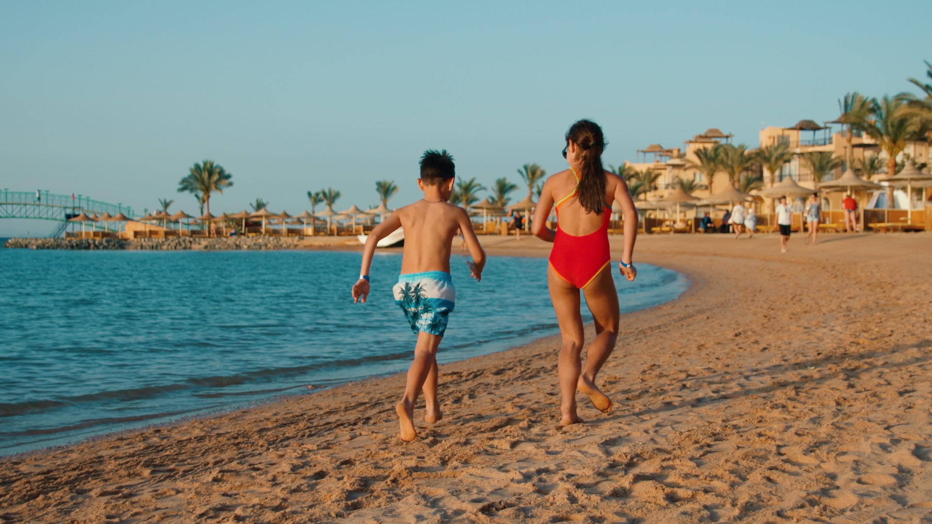 孩子们在日落的海滩上赤脚奔跑视频的预览图