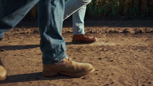 在秋季乡村特写镜头中农学家靴一起行走干燥的地面土壤视频的预览图