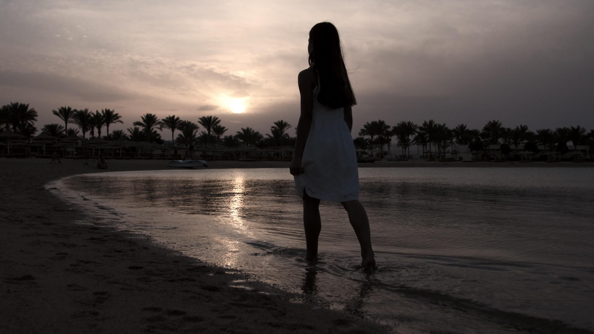 赤脚女孩在日落海滩上行走视频的预览图