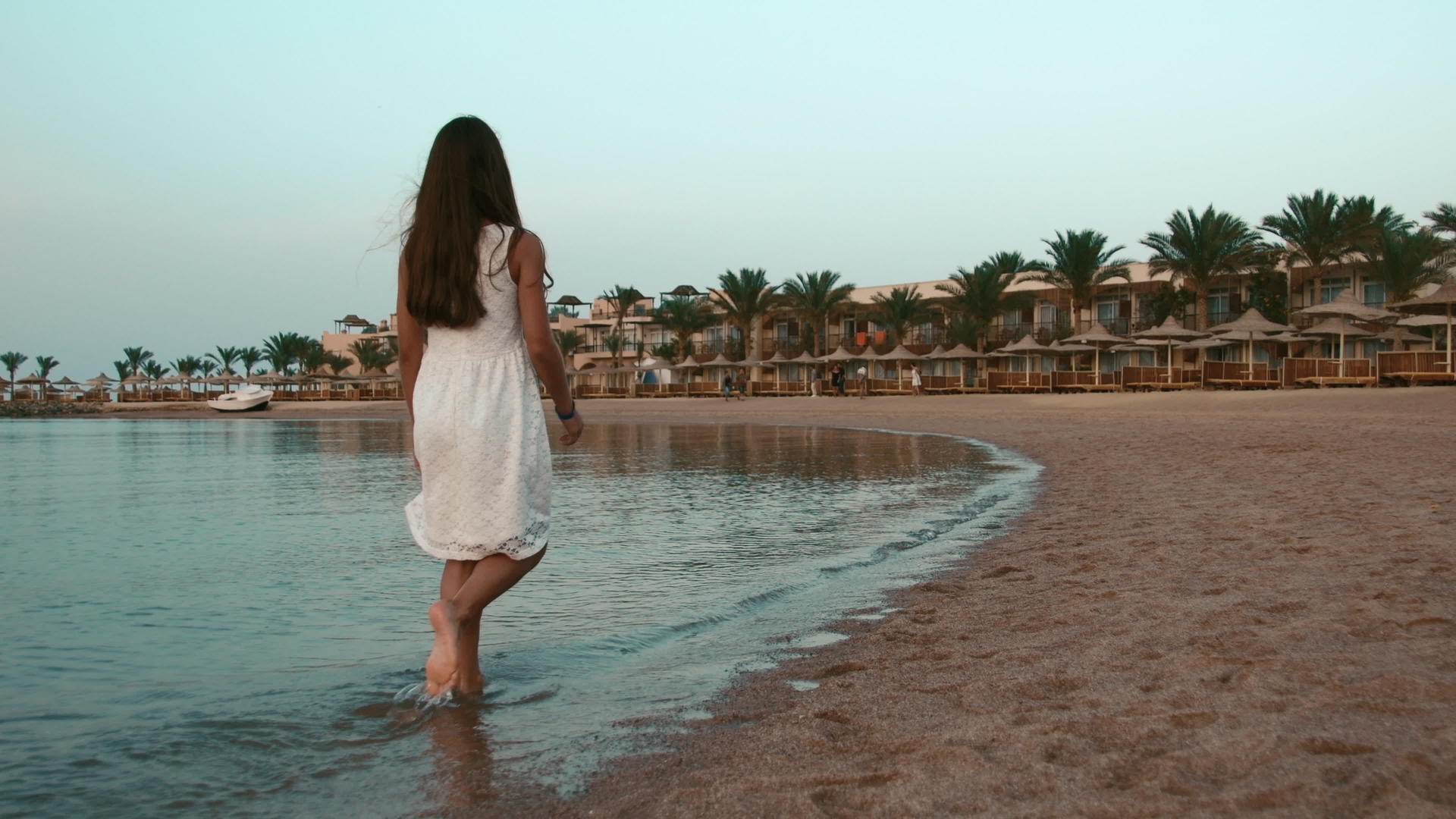 赤脚的小女孩在海边散步视频的预览图