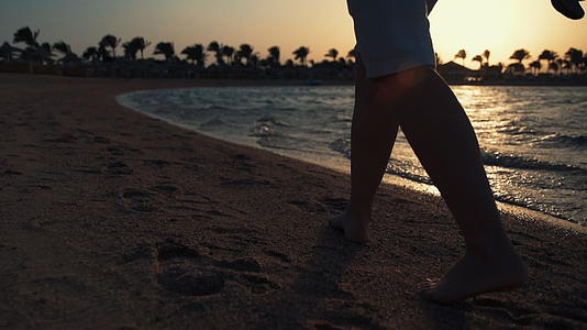 赤脚的年轻女性在沙滩上行走视频的预览图