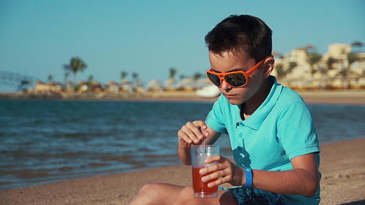 小男孩在度假胜地的海滩上享受愉快的时光视频的预览图