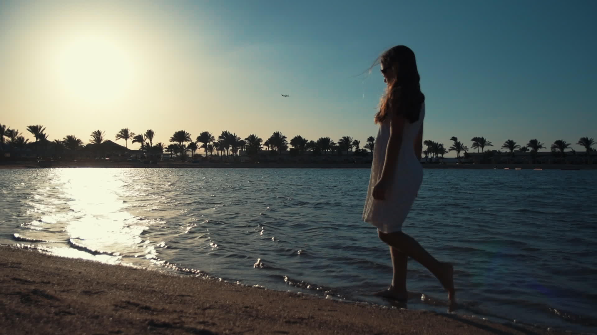 美丽的小女孩在日落时沿着海湾散步视频的预览图