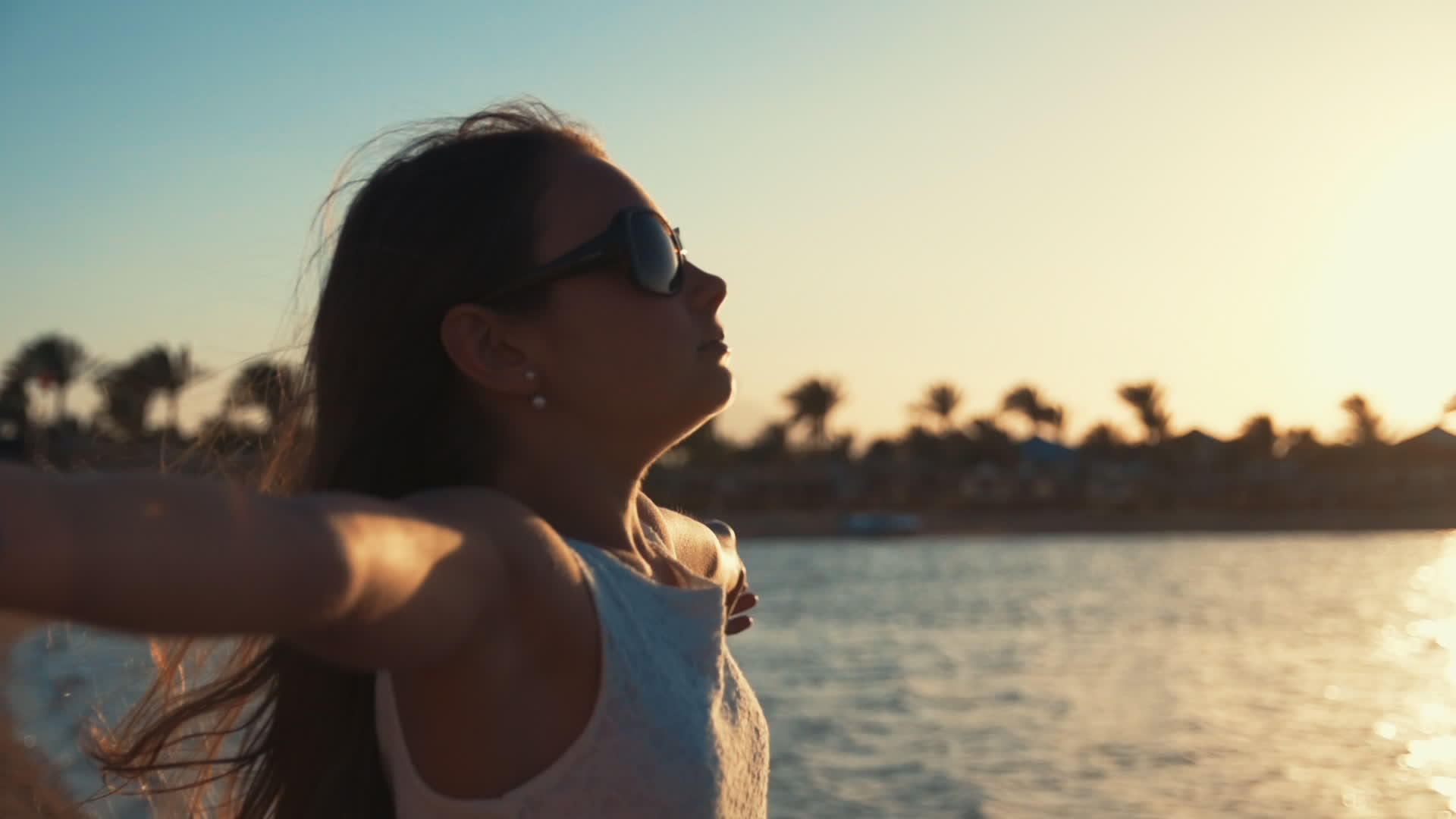 小女孩张开双臂在受日落海滩的愉快时光视频的预览图