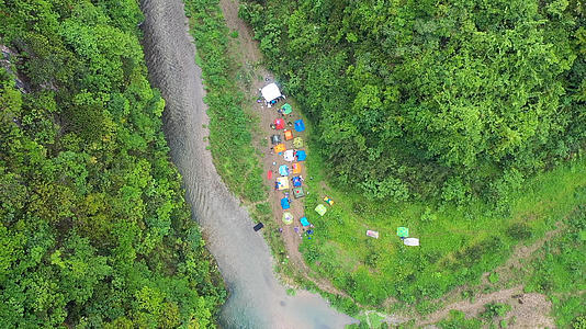 户外山地溪流边露营航拍视频视频的预览图