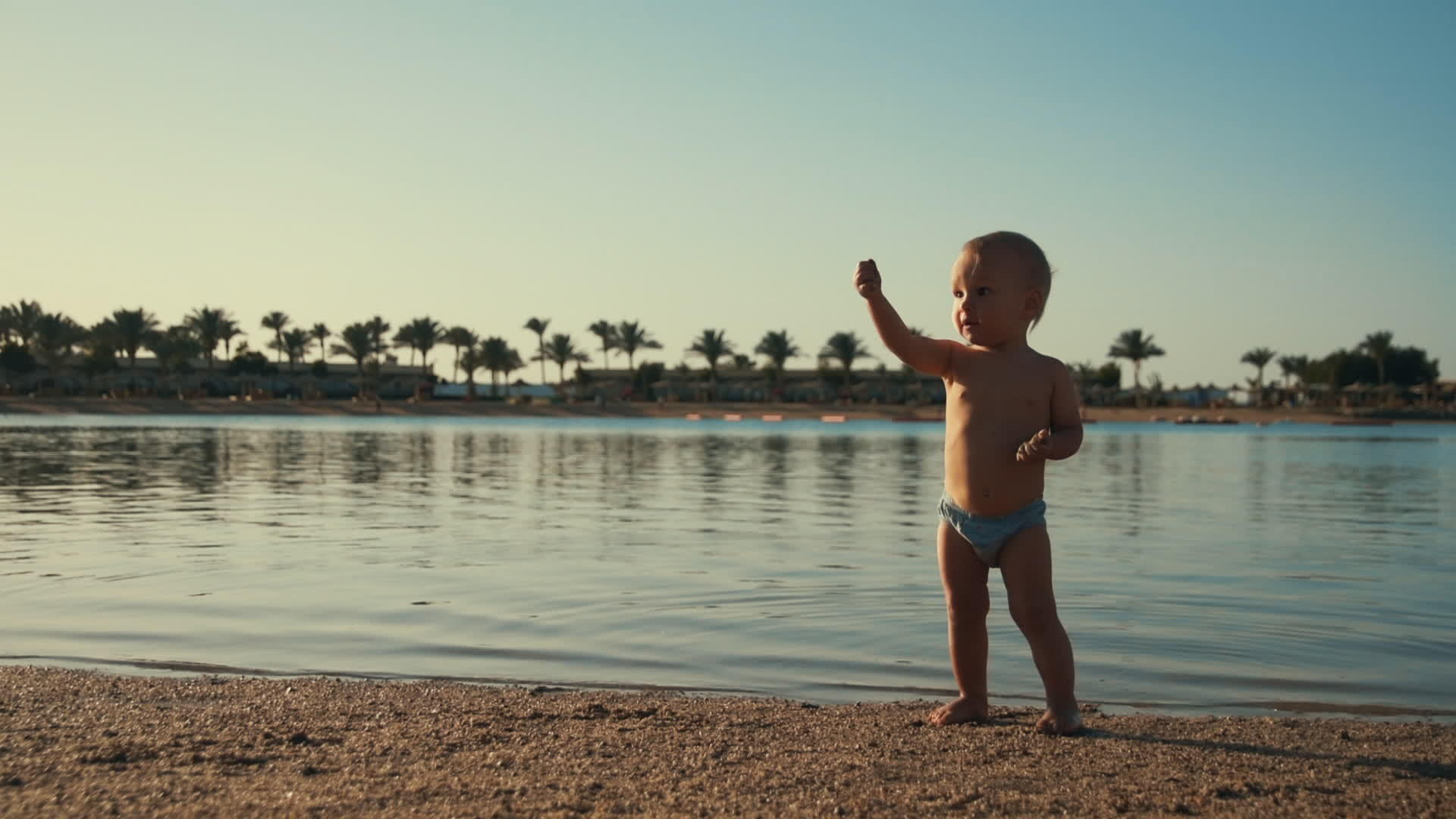 可爱的婴儿男孩在海滩上玩耍视频的预览图