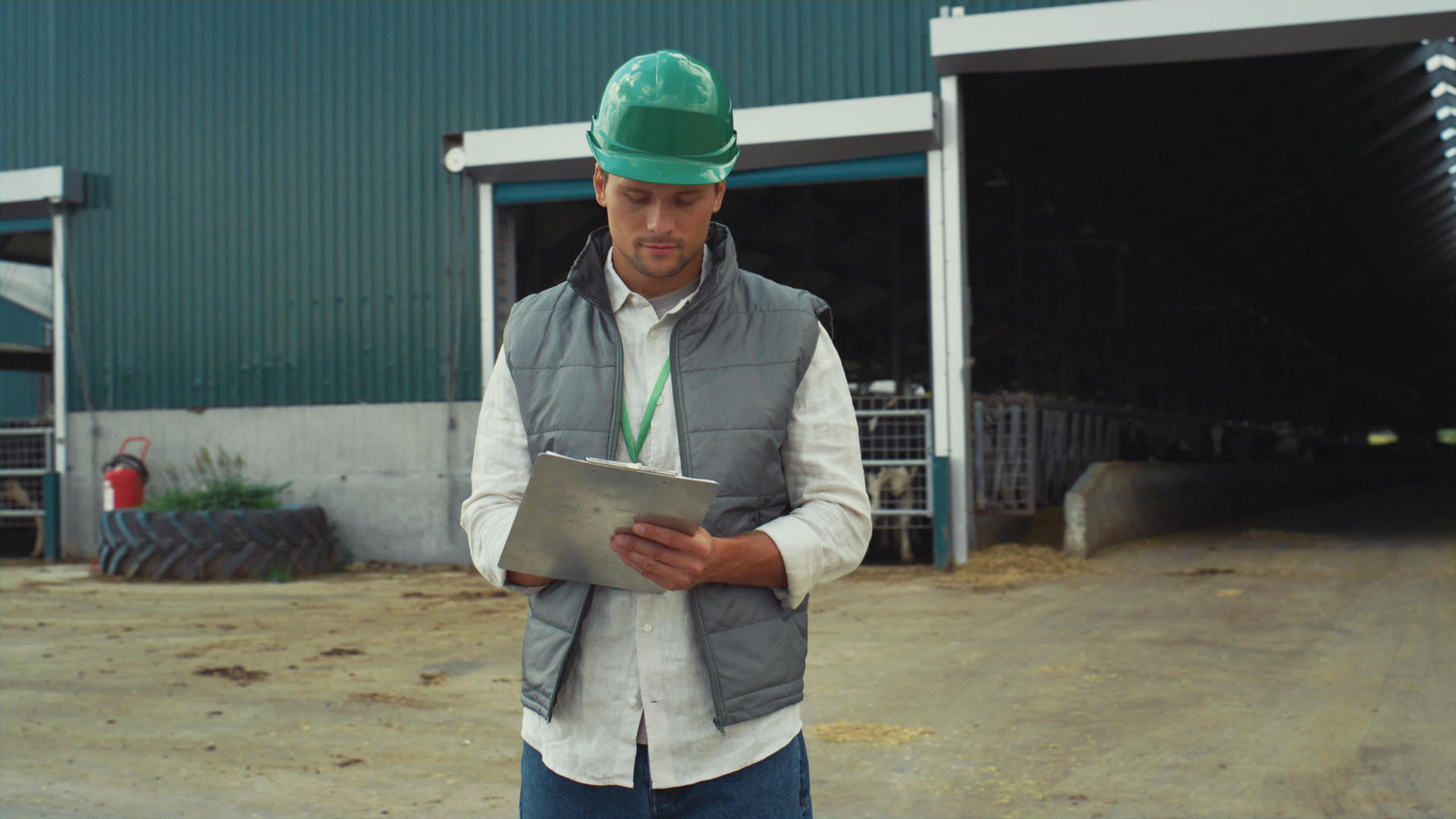 专业工程师戴着防护头盔在现代牛棚建筑中做笔记视频的预览图
