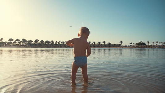 可爱的宝宝在夏天的海滩上玩水视频的预览图