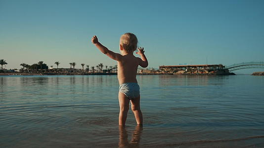 小男孩在夏天的海滩上玩耍视频的预览图