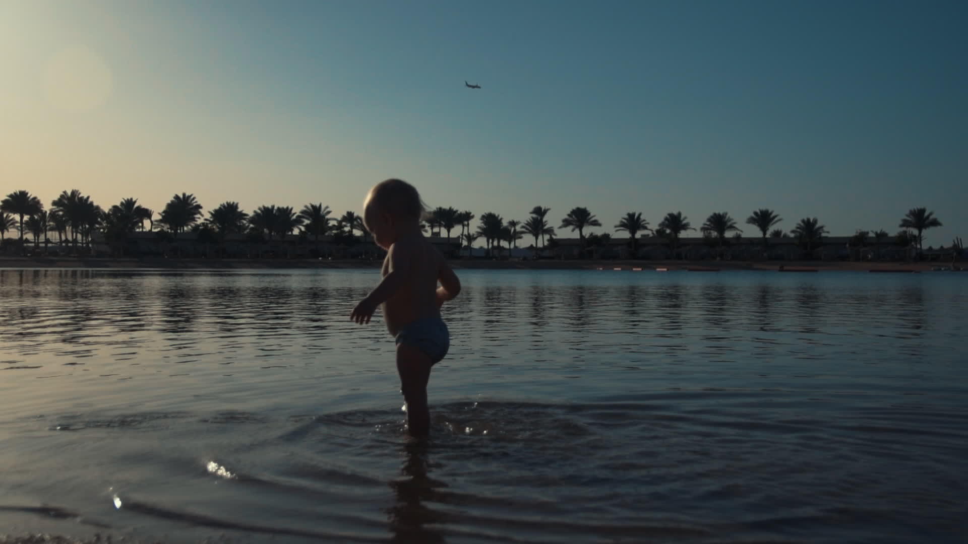 可爱的宝宝在海边的水里走来走去视频的预览图