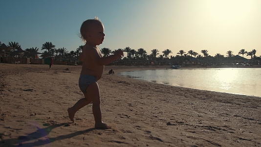 活跃可爱的宝宝在美丽的海边奔跑玩耍视频的预览图
