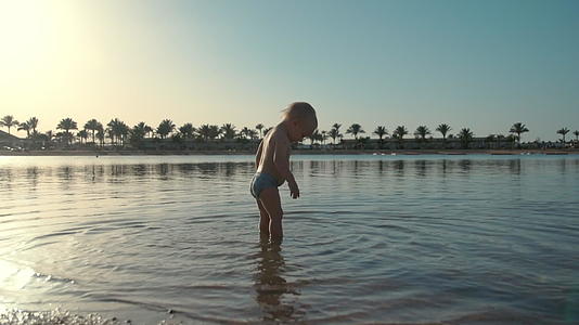 可爱的宝宝在海边玩水视频的预览图