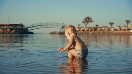 可爱的宝宝在美丽的海边玩水视频的预览图