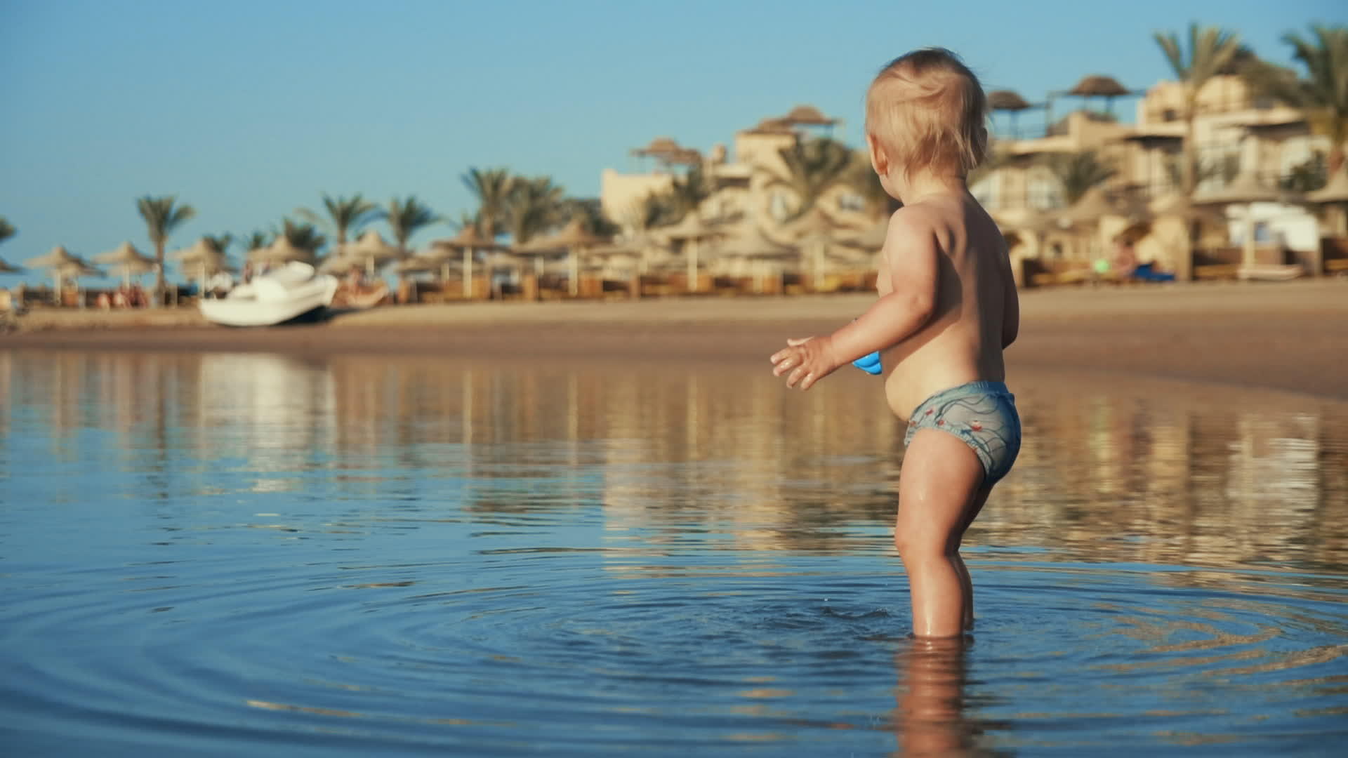 快乐的小男孩在海边玩水视频的预览图