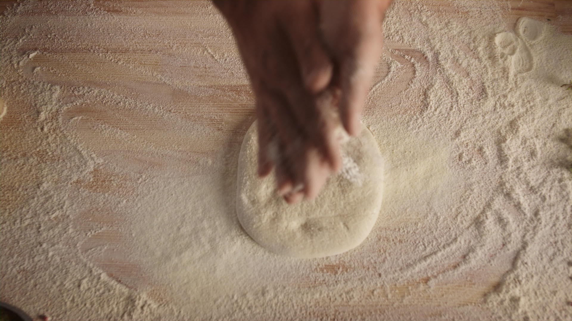 厨师在意大利比萨餐厅的厨房里用手揉面团视频的预览图