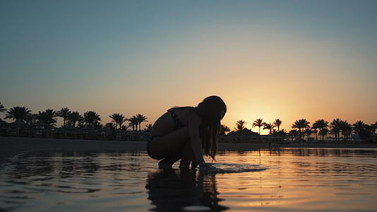 美丽的小女孩在清晨度假胜地的水中放松视频的预览图