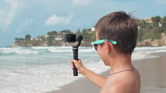 在海边拍vlog快乐的小男孩视频的预览图