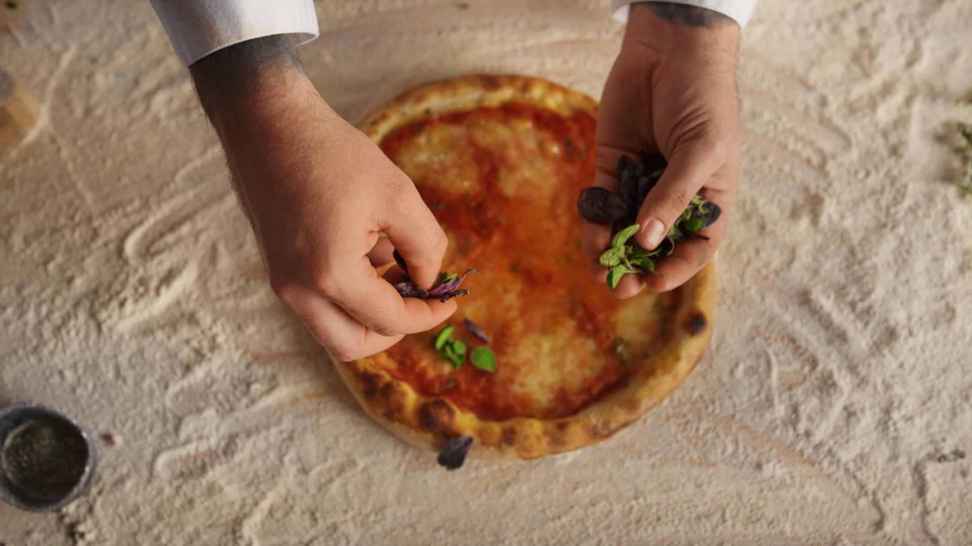 厨师手在餐厅准备食谱在意大利比萨饼上添加配料视频的预览图