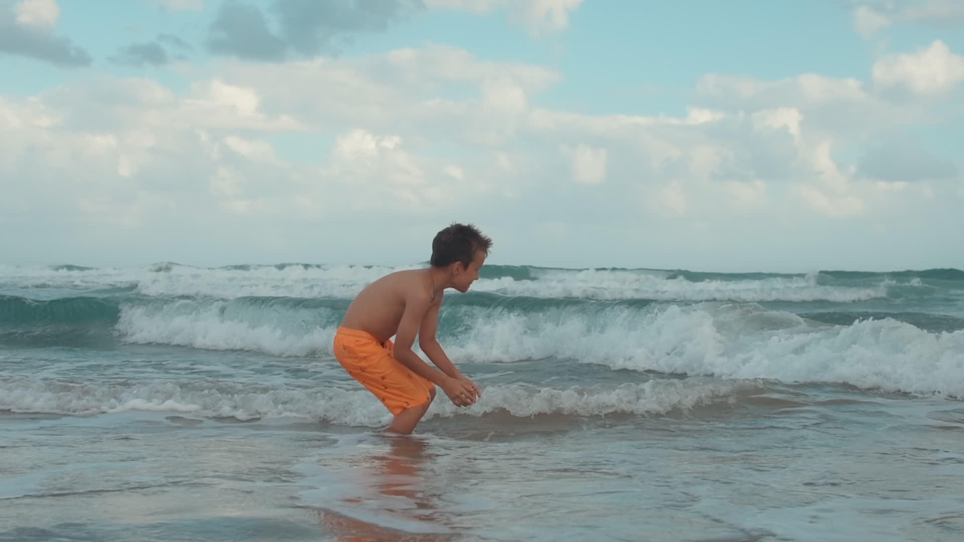 快乐的男孩在海边玩得很开心视频的预览图