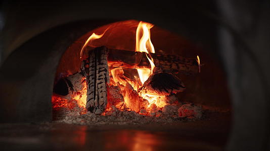 木柴在意大利餐厅厨房燃烧石烤箱视频的预览图