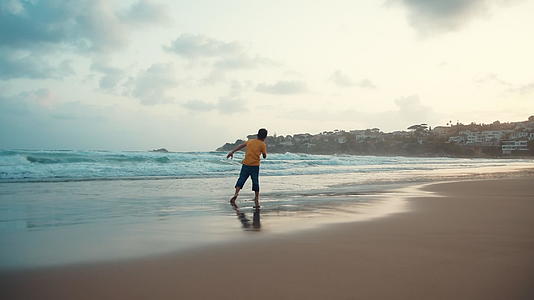 快乐的小男孩在海边玩耍视频的预览图