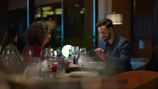 多民族夫妇在优雅的夜间餐厅享受浪漫的晚餐约会视频的预览图