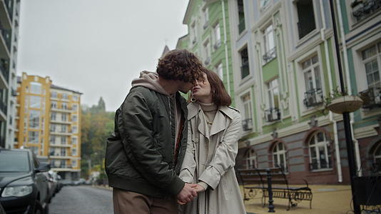 在户外牵手的情侣男人和女人在城市街道上接吻视频的预览图