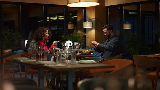 两对情人在餐厅用手机拍照视频的预览图