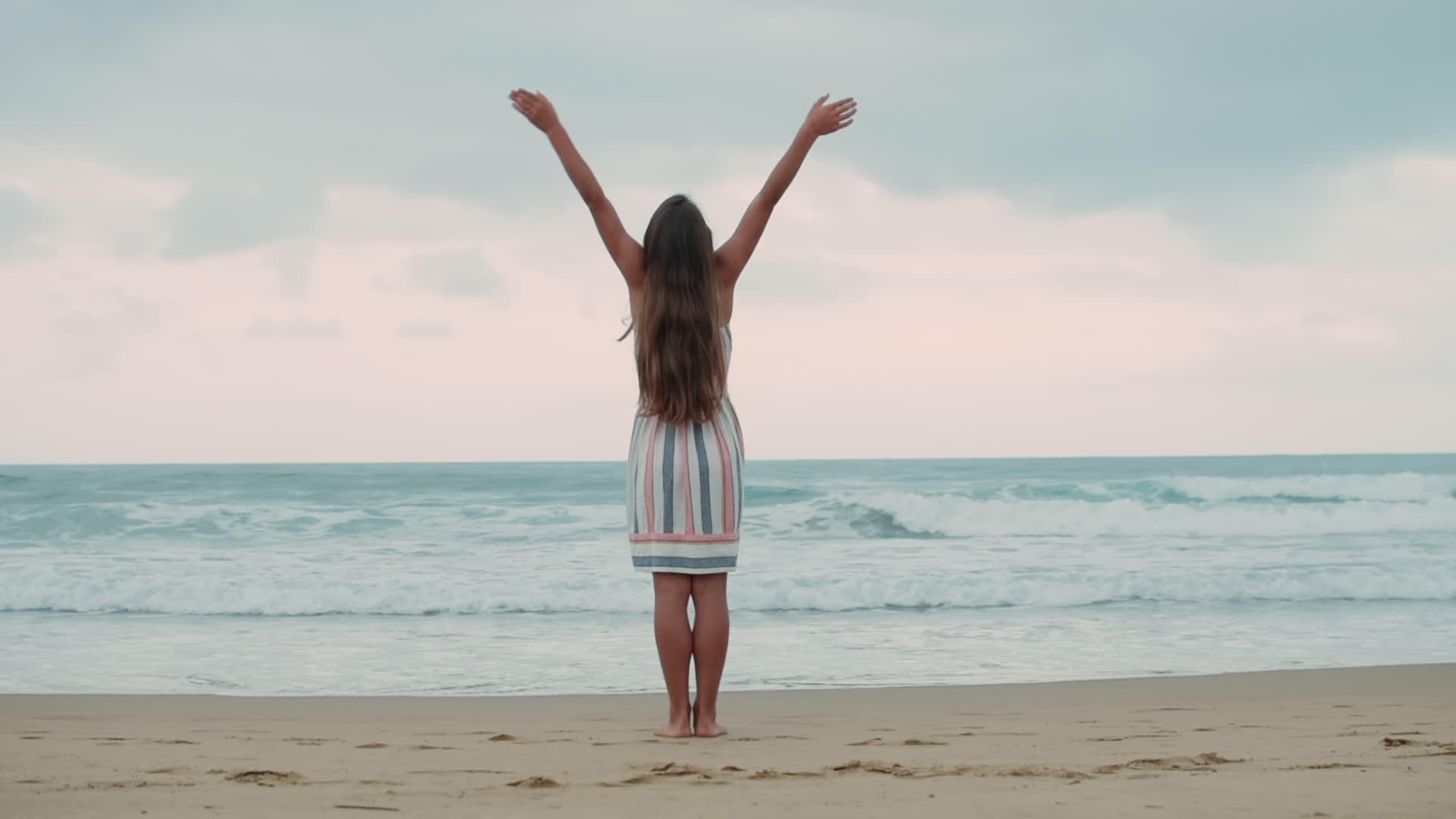 小女孩举起手臂在海边的小女孩视频的预览图