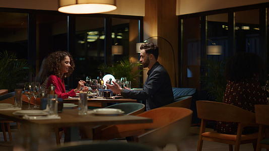 晚上微笑的夫妇坐在餐馆里视频的预览图