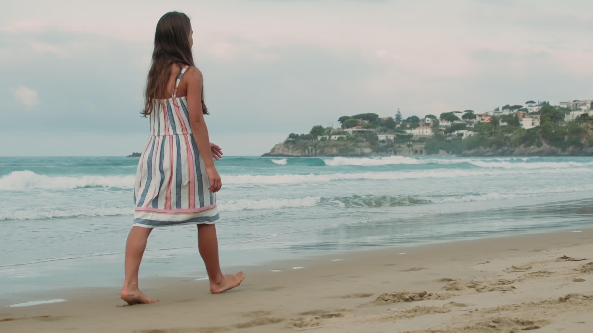 小女孩在海滩上散步视频的预览图
