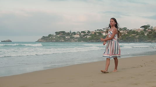 快乐的小女孩在海滩上跳跃视频的预览图