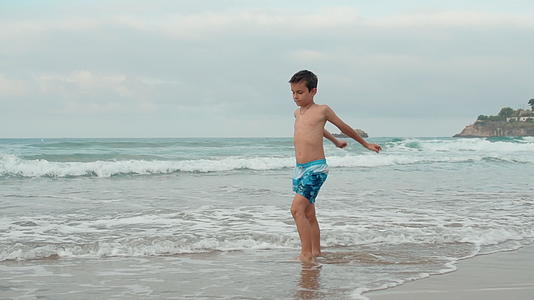 快乐的男孩在海边度暑假视频的预览图