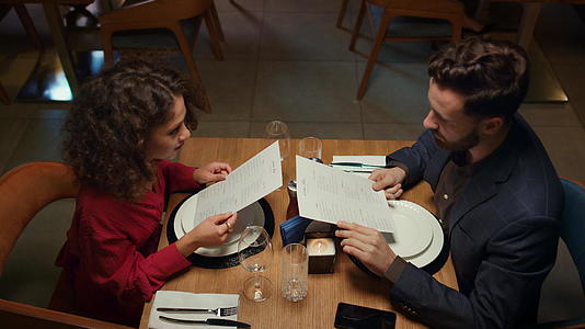 情人在晚餐约会时看餐厅菜单视频的预览图